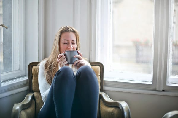 A woman relaxing on a chair with a hot cup of tea