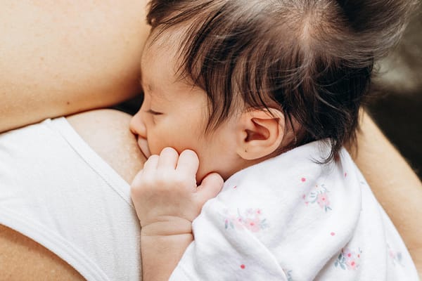 An intimate scene of a baby breastfeeding, showcasing maternal love and care.
