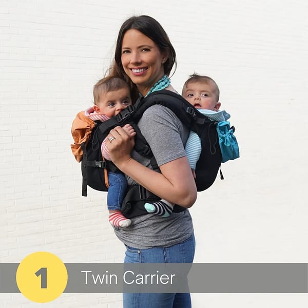 A happy mom models the twingo carrier, which is holding her adorable twin babies