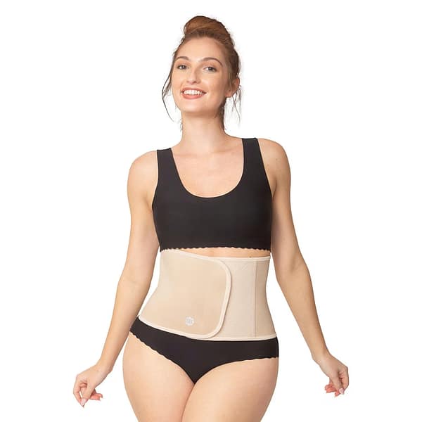 A happy woman, with hair up, modelling a beige waist trainer